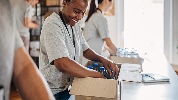 Photo of women packing bottles of water into boxes